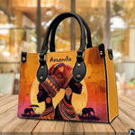 African sunset artwork presented resting on a wooden cafe tabletop against a blurred indoor setting.