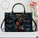Front view of floral afro handbag with butterflies and gold accents