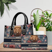Lion portrait handbag and matching zip wallet shown together on wooden tabletop beside houseplant.