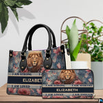 Lion portrait handbag and matching zip wallet shown together on wooden tabletop beside houseplant.