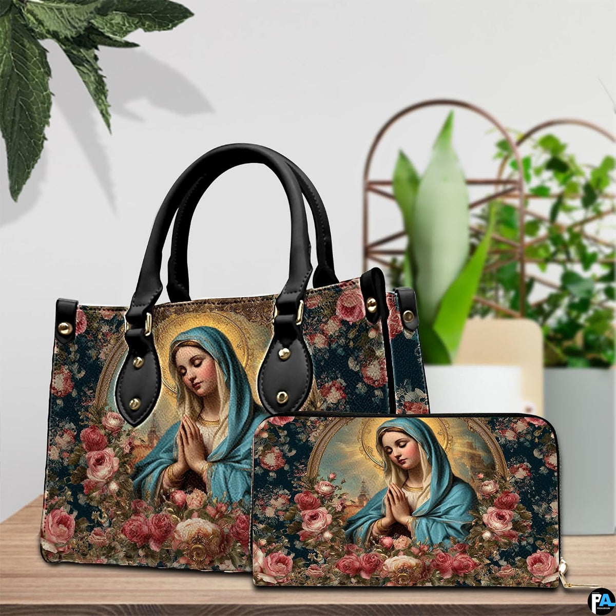 Devotional handbag and wallet set displayed on wooden table with green houseplants