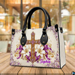 Purple and gold cross devotional handbag standing upright on a cafe table.