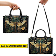 Front view of Art Deco dragonfly handbag featuring gold filigree mandala medallion on dark teal