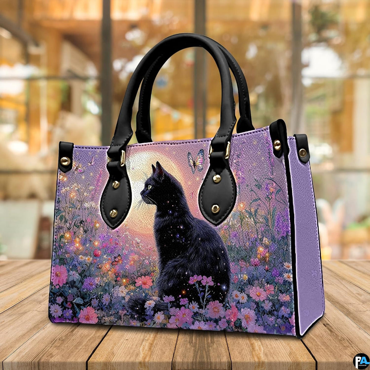 Cafe setting presenting black cat butterfly artwork resting on a wooden tabletop near windows.