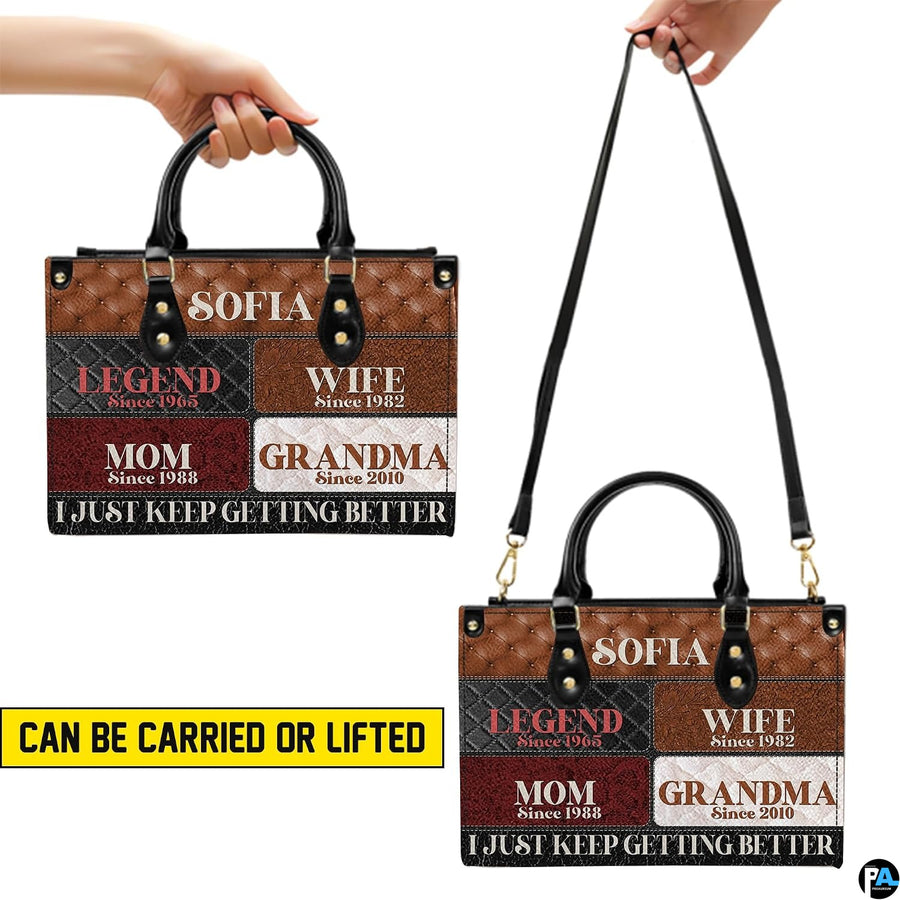 Side profile view of structured patchwork handbag showing sleek silhouette and black carrying handles.