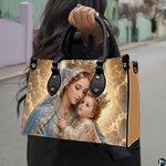 Side profile view of structured Madonna and Child handbag showing silhouette and black handles