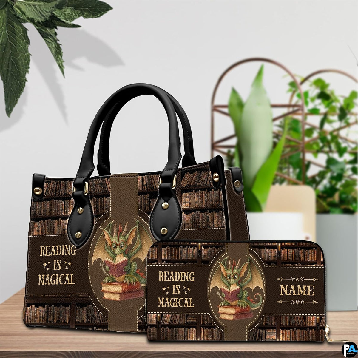 Handbag displayed beside matching zippered wallet with dragon library artwork on a wooden table