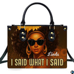 Front view of structured handbag featuring afro queen graphic art with dark sunglasses and gold hoop accents.
