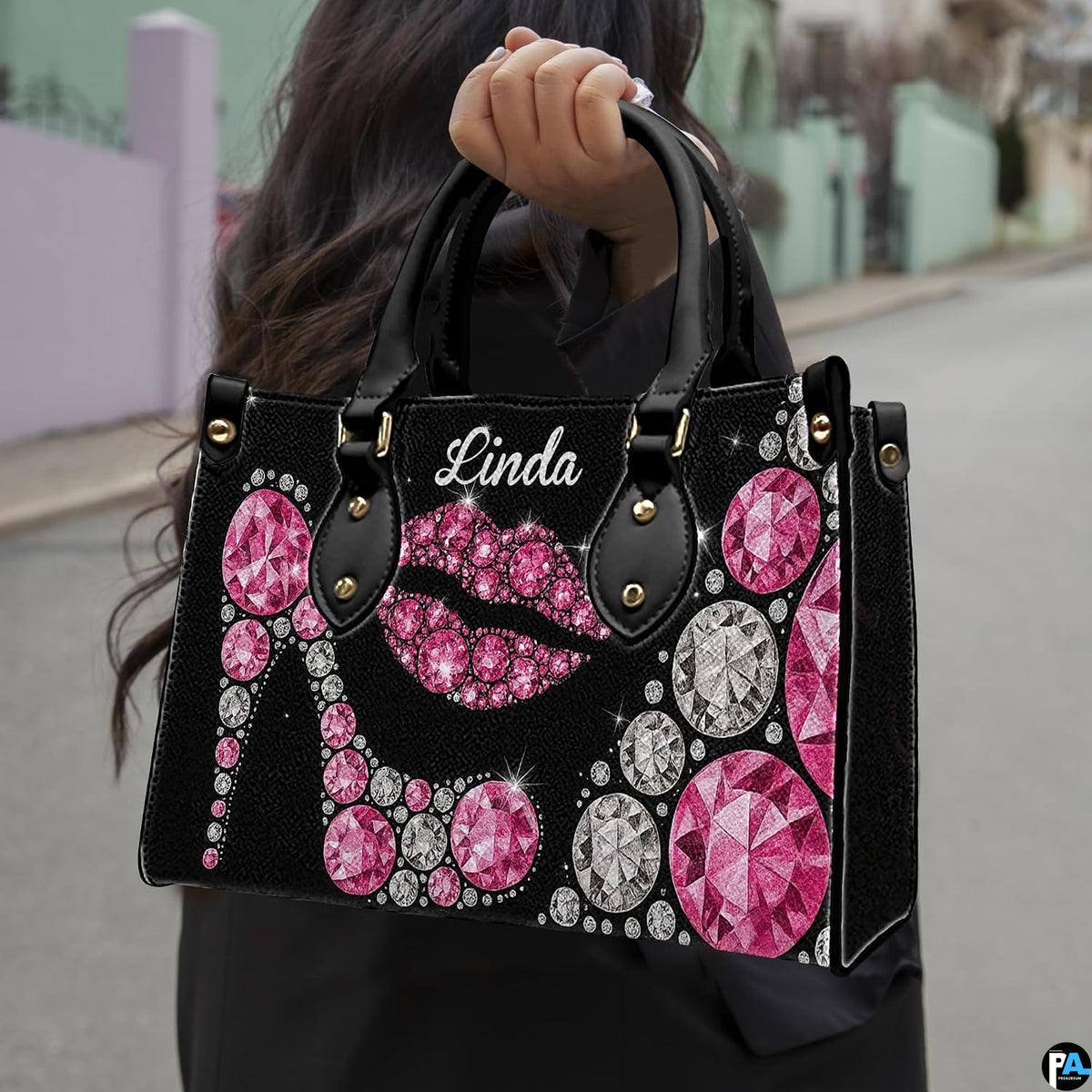 Outdoor street perspective showing glamorous pink crystal stiletto accessory carried by handle.
