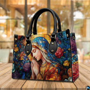 Stained glass Virgin Mary handbag staged outdoors on a wooden cafe patio table
