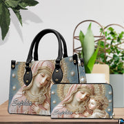Matching Madonna and Child handbag and wallet set displayed in botanical interior