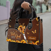Front view of yellow butterfly purse showing sunflower wings, fluttering butterflies, and chestnut backdrop.