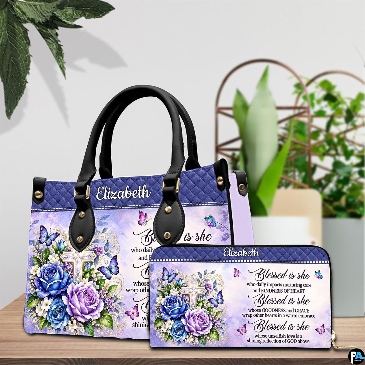 Floral cross handbag and wallet displayed on wooden table beside potted plant.