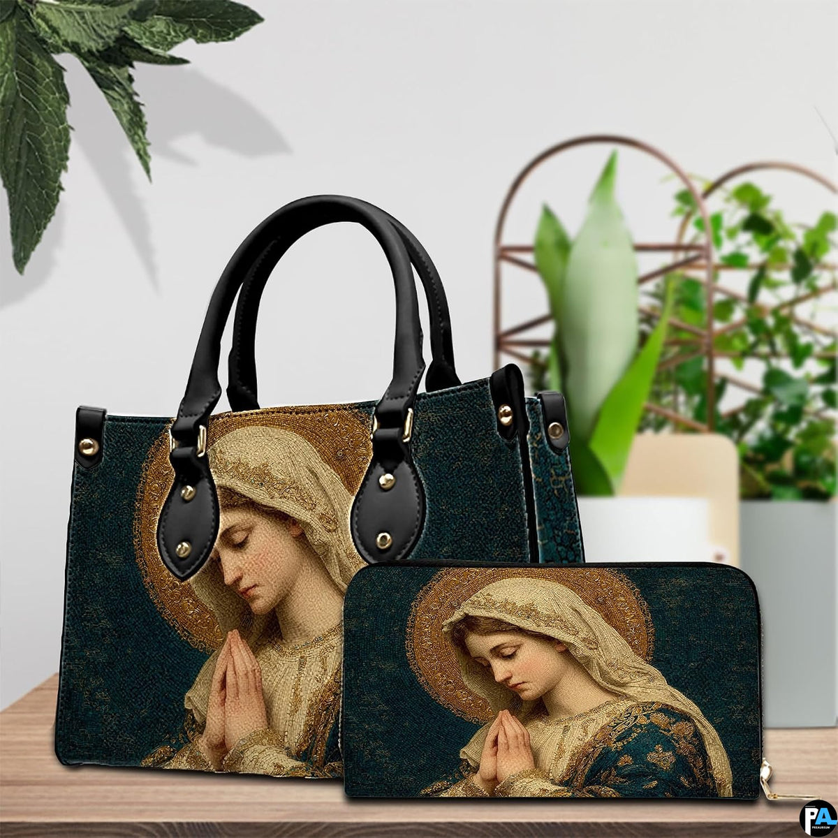 Devotional mosaic handbag and matching wallet staged on wooden table next to potted plant