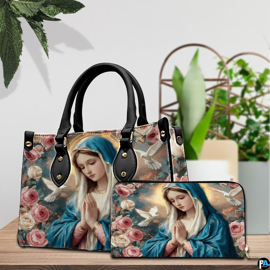 Virgin Mary devotional handbag and matching zippered wallet displayed on wooden table.