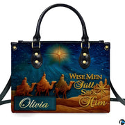 Close-up front view of handbag showing three camel travelers and shining celestial star