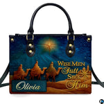Close-up front view of handbag showing three camel travelers and shining celestial star