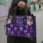 Front view of purple handbag featuring tufted diamond pattern, mauve roses, and colorful butterflies.