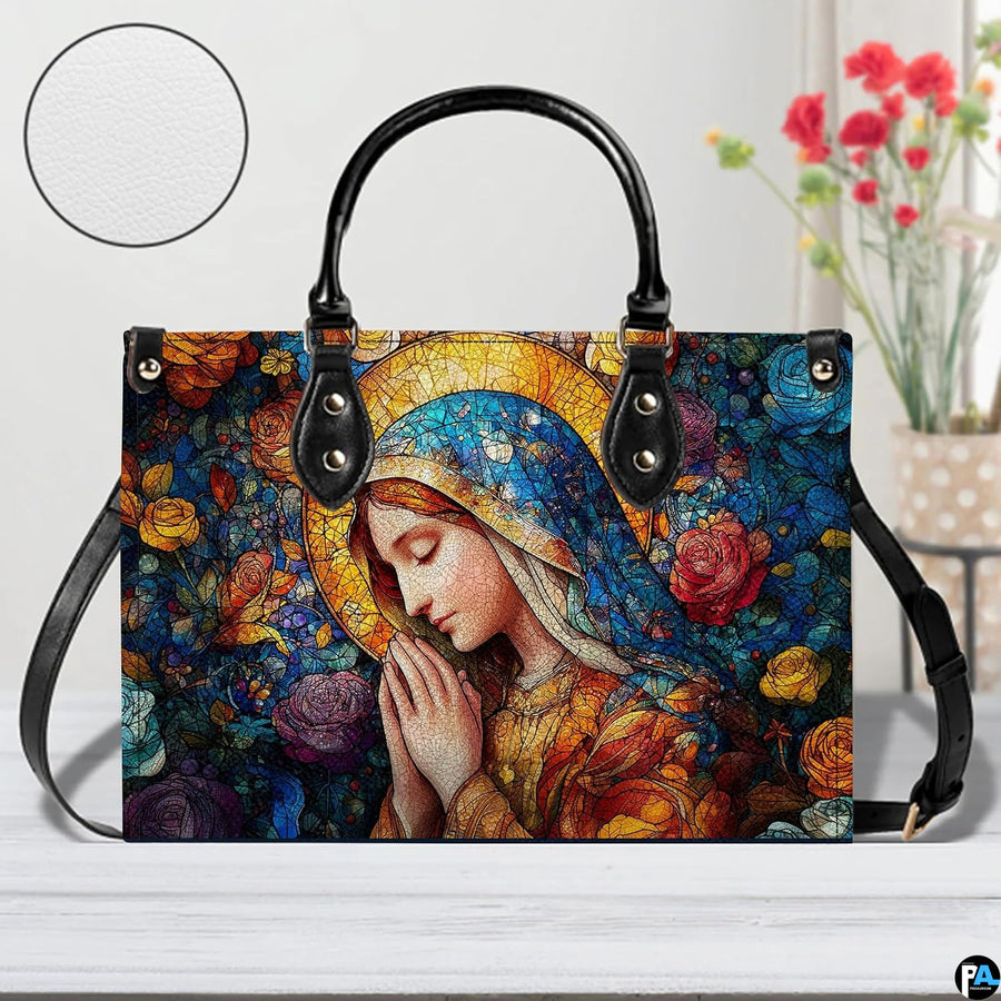 Praying Mary rose garden handbag displayed indoors on a white table beside flowers