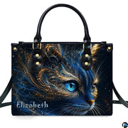 Studio presentation of cosmic blue cat artwork showing swirling gold filigree and glowing blue eyes on white surface.