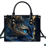 Studio presentation of cosmic blue cat artwork showing swirling gold filigree and glowing blue eyes on white surface.
