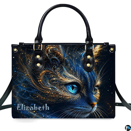 Studio presentation of cosmic blue cat artwork showing swirling gold filigree and glowing blue eyes on white surface.