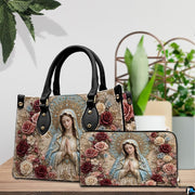 Baroque Virgin Mary floral handbag and coordinated wallet displayed on tabletop with greenery