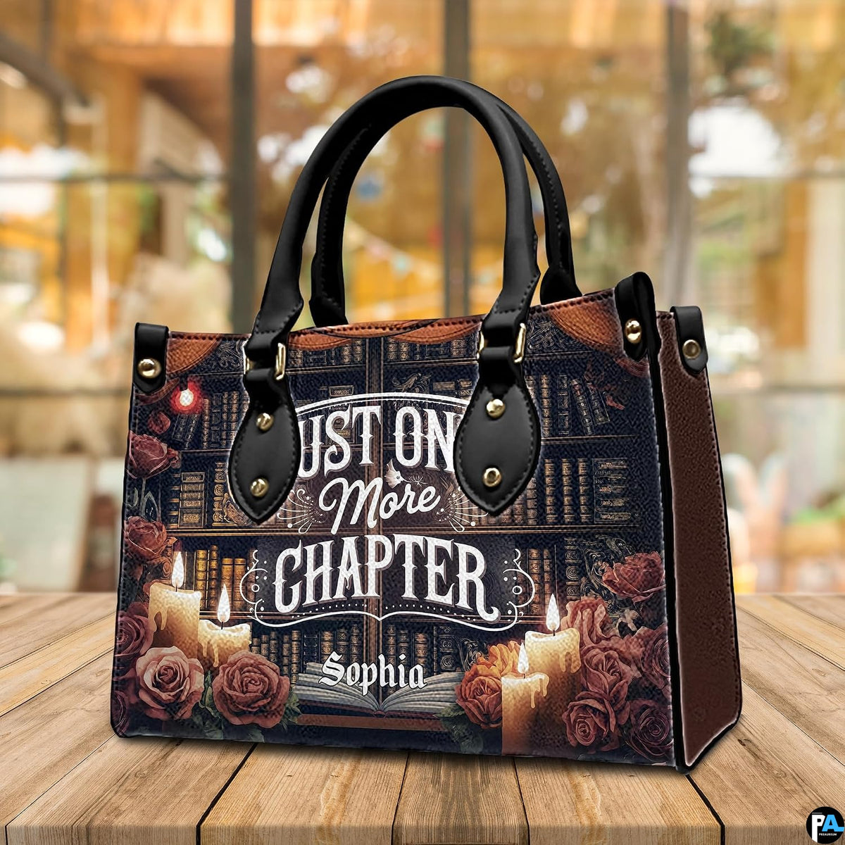 Angled tabletop perspective of dark academia book lover handbag on natural wood planking.