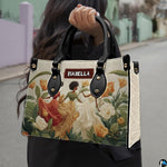Model holding the botanical dancing women handbag outdoors along an urban street.