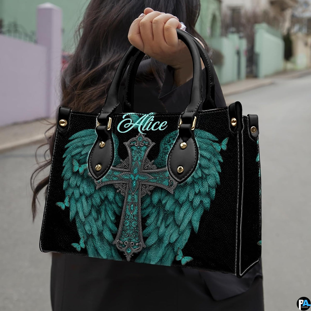 Turquoise angel wings cross handbag paired with matching wallet against black background.