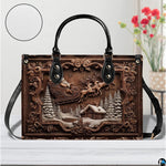 Holiday handbag with carved wood Santa scene displayed on a white table surface with background flowers