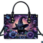 Frontal studio view showcasing the floral witch cat, purple blossoms, and crescent moon on white surface.