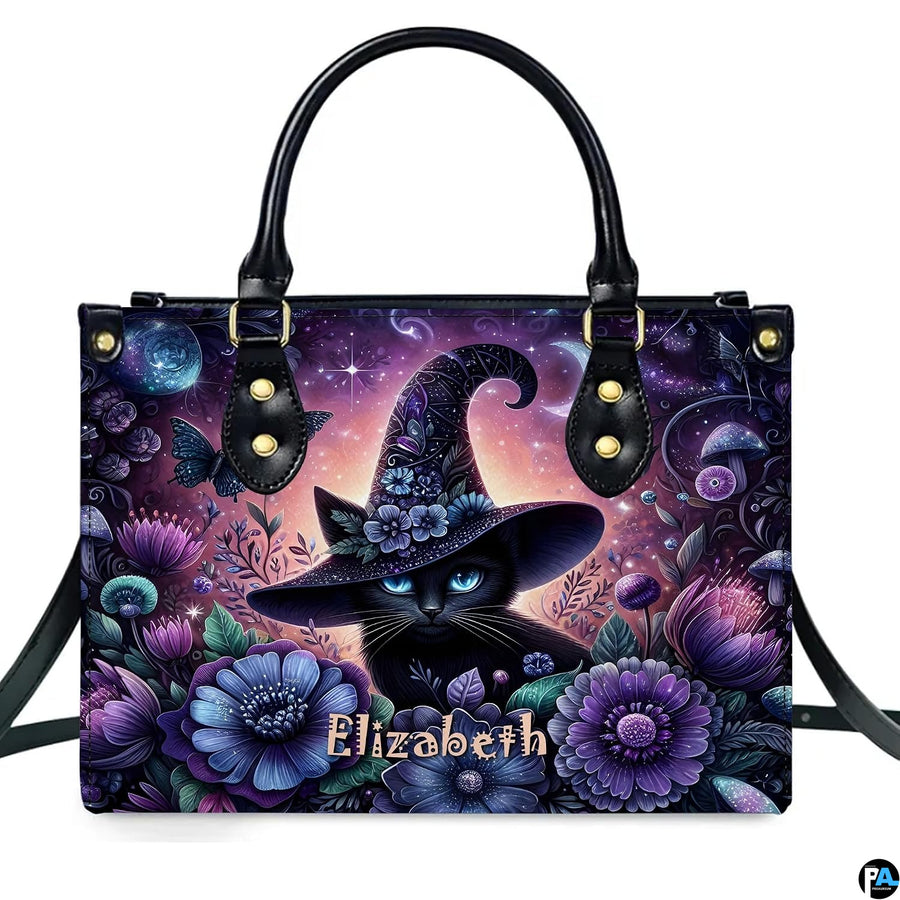 Frontal studio view showcasing the floral witch cat, purple blossoms, and crescent moon on white surface.