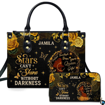 Black and gold handbag with matching wallet featuring floral woman portrait artwork.