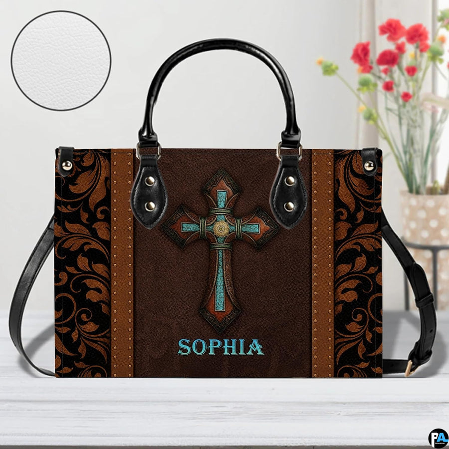Perspective tabletop view of the western cross handbag with a circular material texture swatch inset.