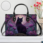 Studio view on white tabletop highlighting stained glass black cat illustration and purple floral arch.