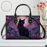 Studio view on white tabletop highlighting stained glass black cat illustration and purple floral arch.
