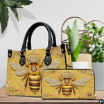 Side profile view of structured bee handbag showing sleek silhouette and black carrying handles.
