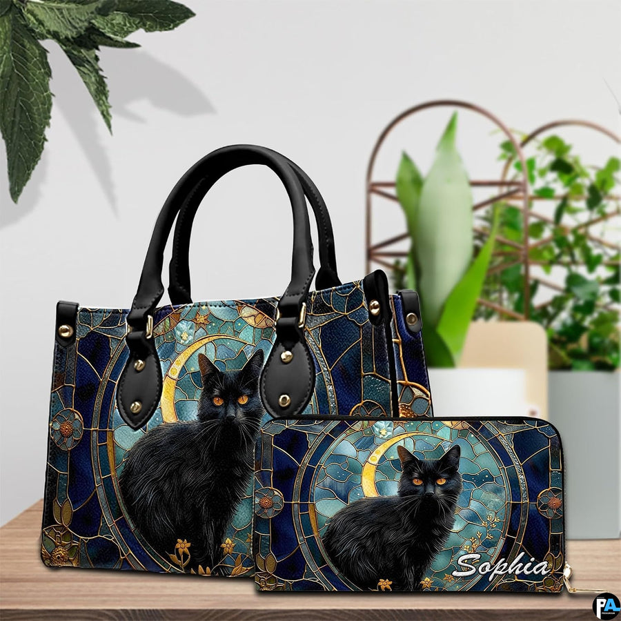 Gothic stained glass black cat artwork displayed on a wooden surface beside house plants.