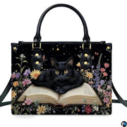 Front studio shot of bookish black cat resting on open book among wildflowers and night starlight.