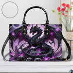 Front view of gothic dragon handbag on white tabletop with circular textured exterior swatch.