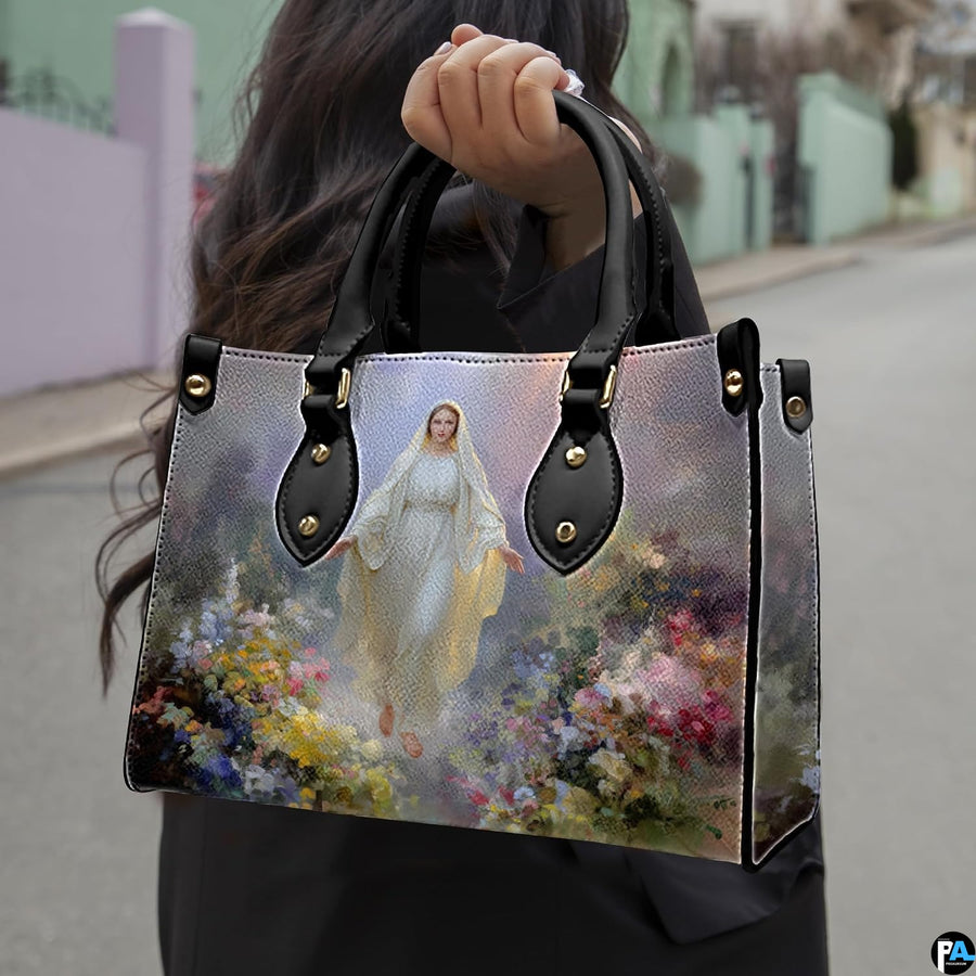 Street lifestyle view of woman carrying Our Lady of Grace wildflower devotional handbag.