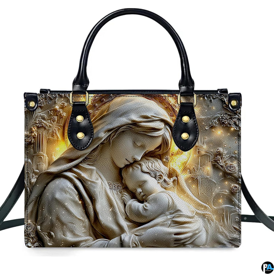 Front view of handbag showing detailed stone relief sculpture of Virgin Mary holding sleeping baby Jesus.