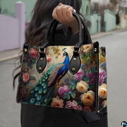 Woman carrying a blue peacock floral handbag by the top handles