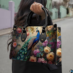 Woman carrying a blue peacock floral handbag by the top handles