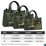 Product breakdown view showing metal handle buckles, removable strap, zipper, and inner lining.