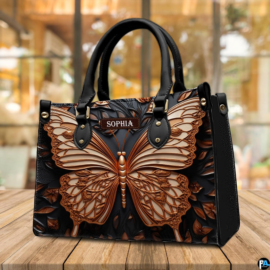 Sculpted bronze butterfly handbag standing on a wooden table in a cafe.