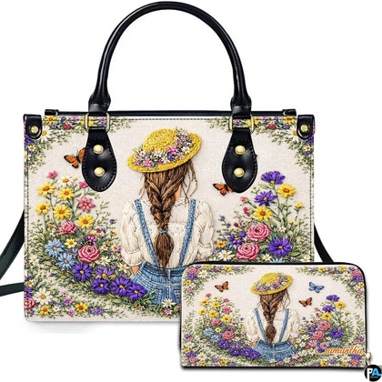 Front perspective of embroidered wildflower girl handbag shown alongside matching accessory with meadow artwork