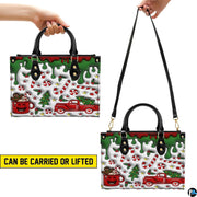 Front view showing dual top handles, attachable shoulder strap, and confectionery holiday drip illustration.