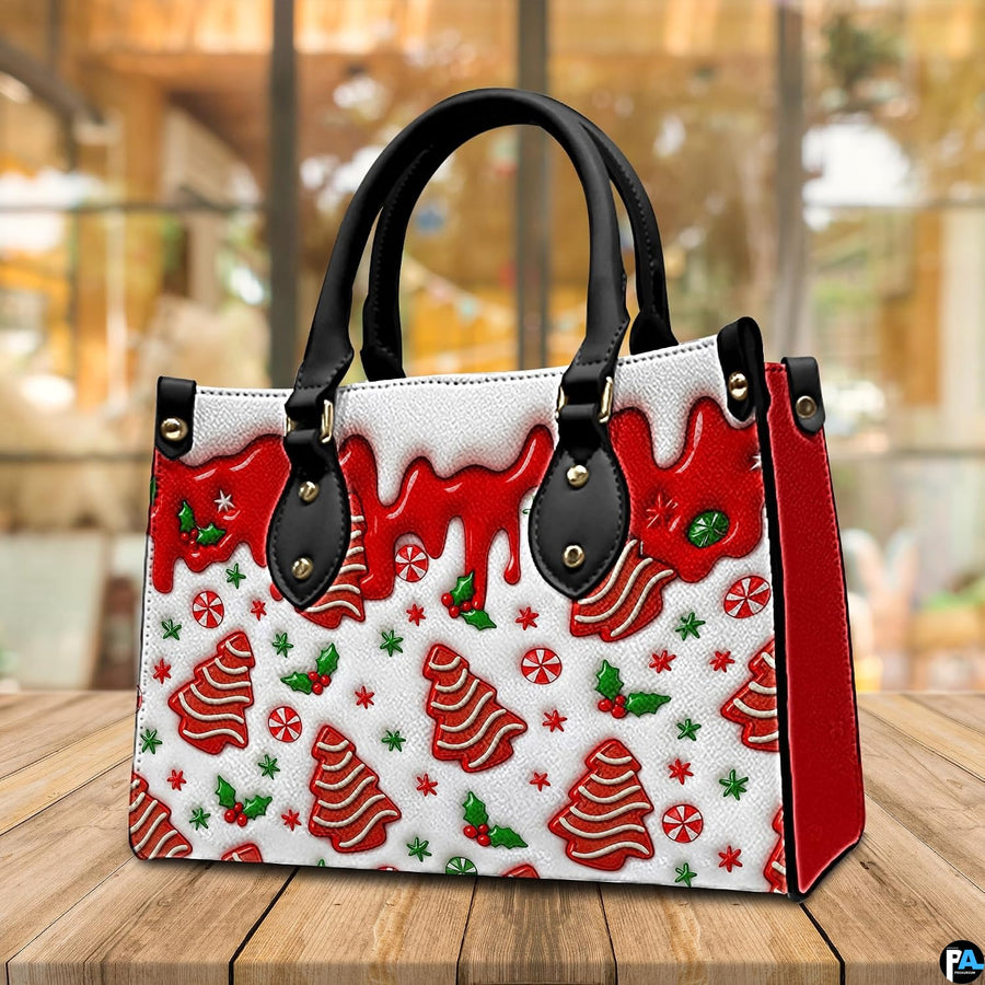 Angled tabletop view of handbag highlighting gingerbread tree print, red side gusset, and dripping glaze motif.